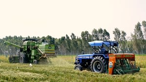 A combine harvester equipped with the Super SMS (left) harvests rice while a tractor equipped with the Happy Seeder is used for direct seeding of wheat. (Photo: Sonalika Tractors)